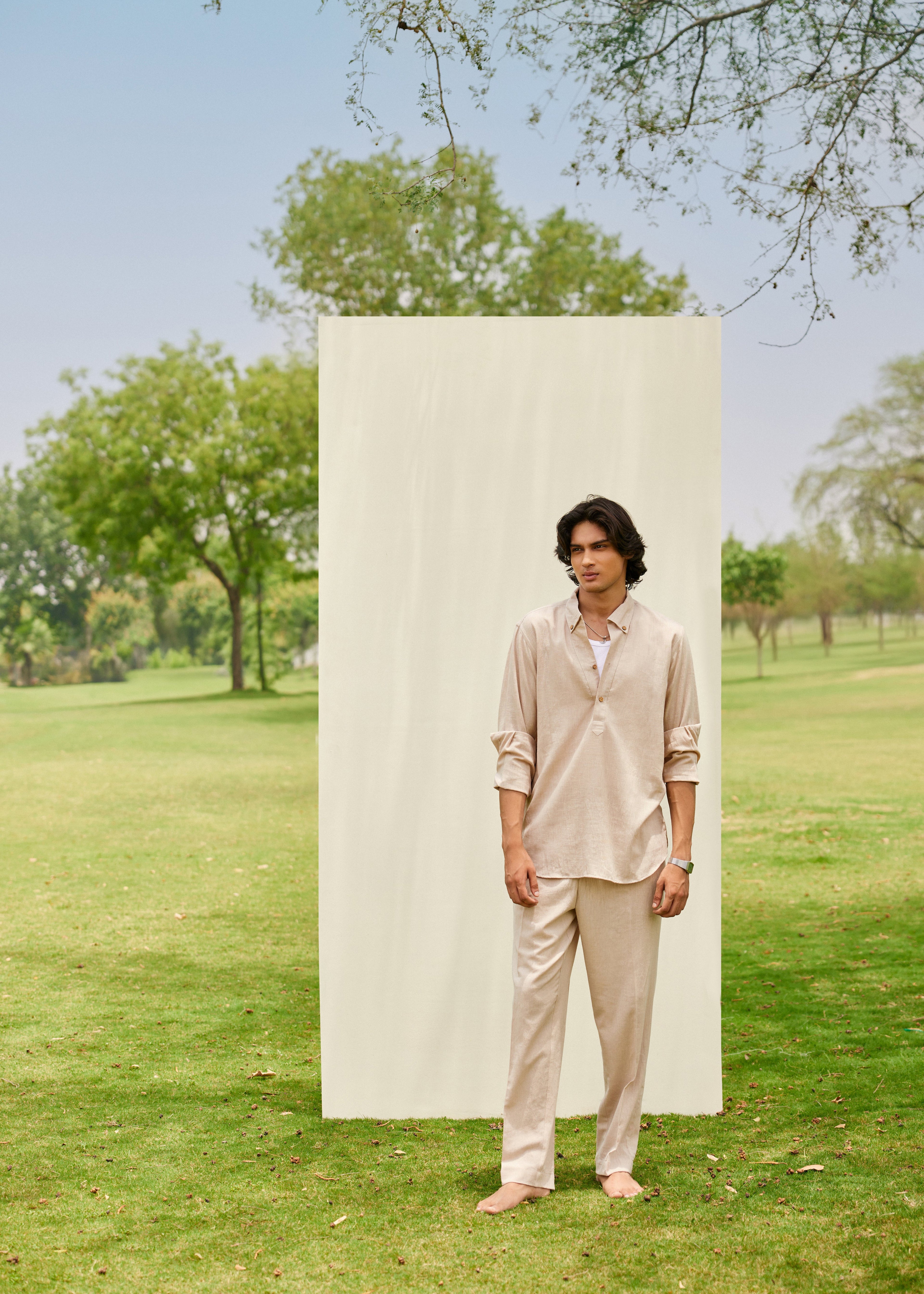 Man standing in a park with a plain white backdrop