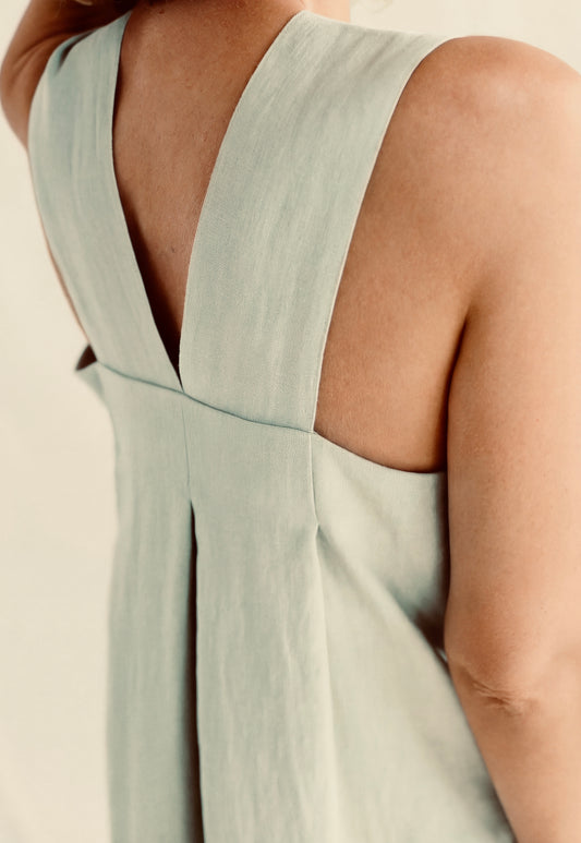 Light green sleeveless dress with a deep neckline on a neutral background