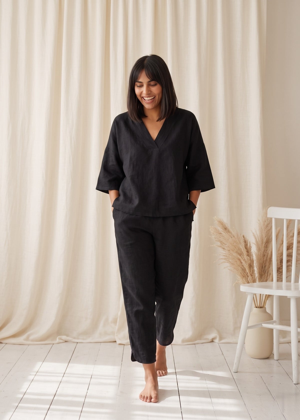 Tide Turn-Around Co-ord Set in Black by Jamies, walking front view with V-neck and curved side-split hems